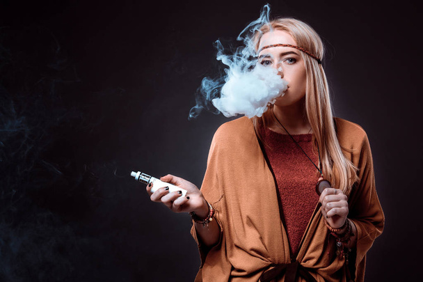 Jeune femme dans le style Boho soufflant la fumée
 - Photo, image