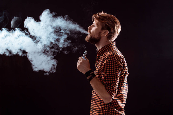 jeune homme fumant cigarette électronique - Photo, image