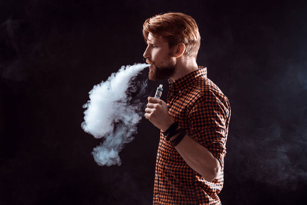 young man smoking electronic cigarette - 写真・画像