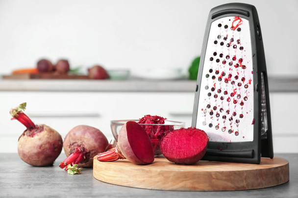 Fresh beetroot and grater on table in kitchen - Foto, Imagem