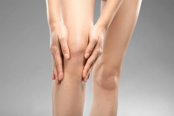 Young woman suffering from leg pain - Foto, afbeelding