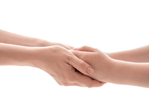Mother and daughter holding hands together on white background, closeup - Valokuva, kuva