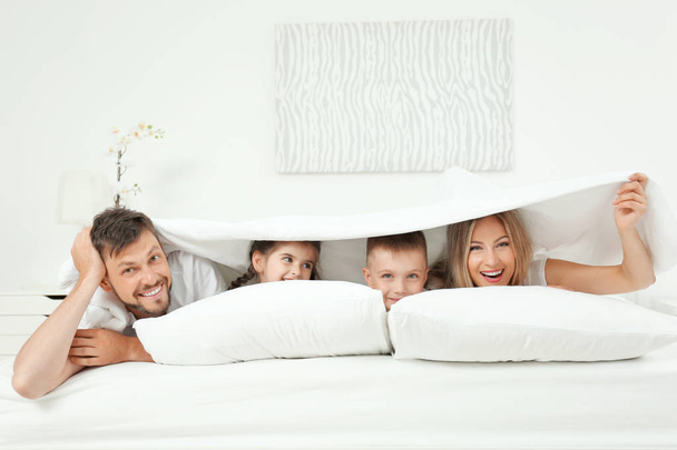 Family lying on bed in hotel room - Fotoğraf, Görsel