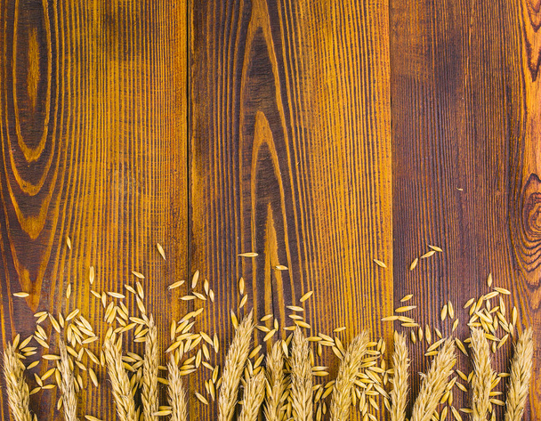 Wheat ears on an old wooden background with copyspace. - Photo, Image