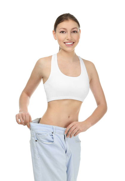 Mulher bonita em jeans oversized no fundo branco. Conceito de dieta
 - Foto, Imagem