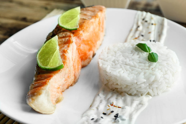 Plate with slice of salmon, rice and delicious sauce  - Foto, Bild