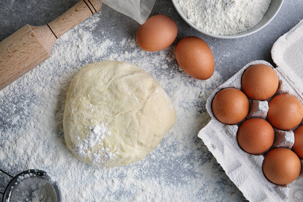 Raw dough, eggs and rolling pin - Photo, Image