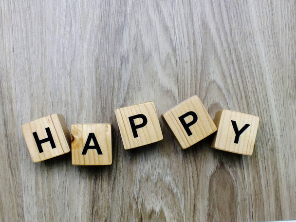 happy word wooden block on wooden background - Foto, Imagem