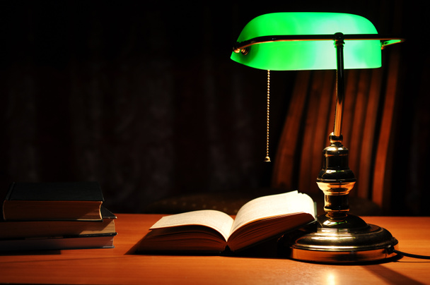 groene tafellamp en geopende boek - Foto, afbeelding