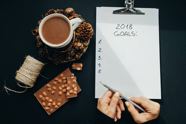 2018 goals list with woman hands, pencil, chocolate, cocoa, cone - Fotó, kép