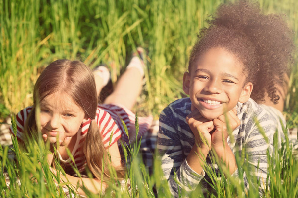 Onnellisia pikkutyttöjä vihreällä niityllä
 - Valokuva, kuva