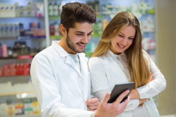 Farmacéuticos usando tableta digital mientras que comprueban la medicina en phar
 - Foto, imagen