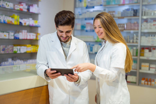 Φαρμακοποιοί χρησιμοποιώντας ψηφιακό tablet κατά τον έλεγχο της ιατρικής στον Τομ της φαρμακοεπαγρύ - Φωτογραφία, εικόνα