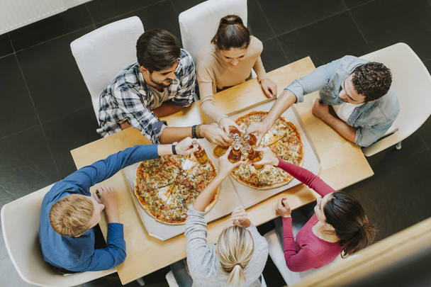 Молодые люди едят пиццу и пьют сидр
 - Фото, изображение