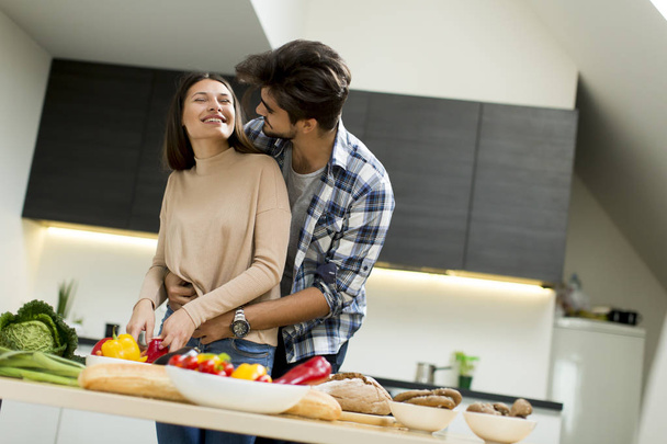 pareja joven divertirse en la cocina moderna  - Foto, imagen