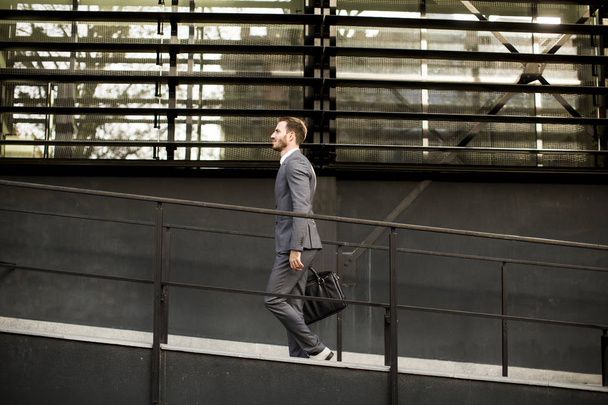 Uomo d'affari in giacca e cravatta con borsa in pelle va al lavoro
 - Foto, immagini
