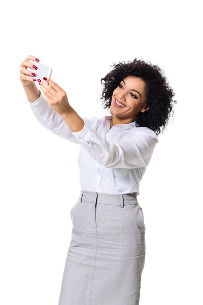 schöne brünette Frau in klassisch weißem Hemd und Rock macht Selfie am Telefon. - Foto, Bild