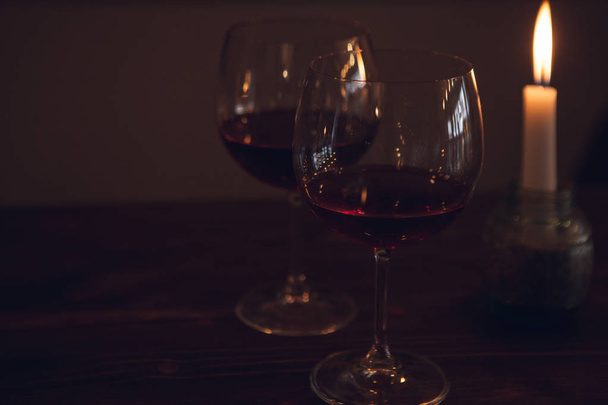 Romantic date. Red wine in focus on foreground - 写真・画像