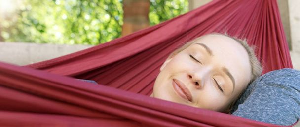 Young woman relaxing in hammock - Fotó, kép