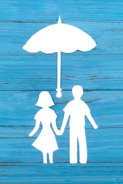 Silueta de papel del hombre y la mujer tomados de la mano bajo el paraguas
 - Foto, Imagen