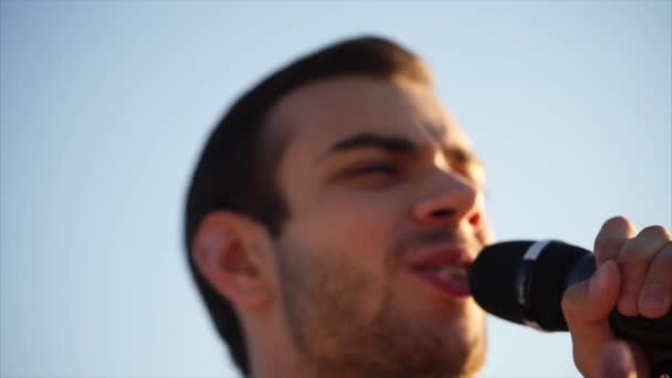 Portrét mladého muže, který zpívá píseň na ulici ve dne - Záběry, video