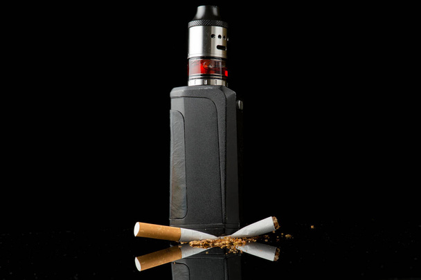 Tabakzigarette unter elektronischer Zigarette zerdrückt - Foto, Bild