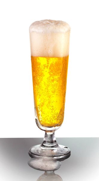 Un vaso desbordante de refrescante cerveza Pilsner
 - Foto, imagen