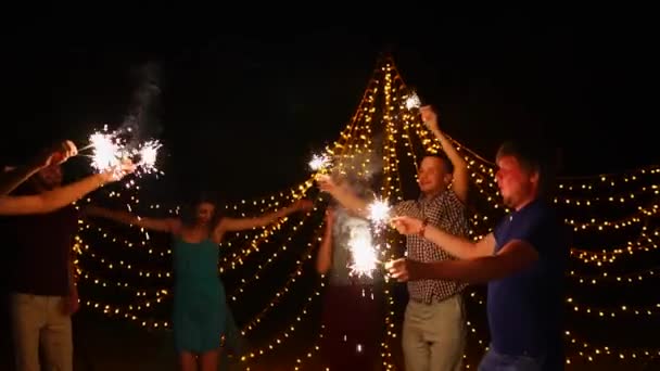 Young people having night beach party and dancing with sparklers - Footage, Video
