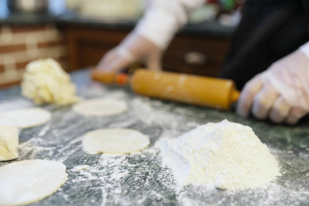 Mężczyzna kucharz używa składników do przygotowania produktów mąki na kitch - Zdjęcie, obraz