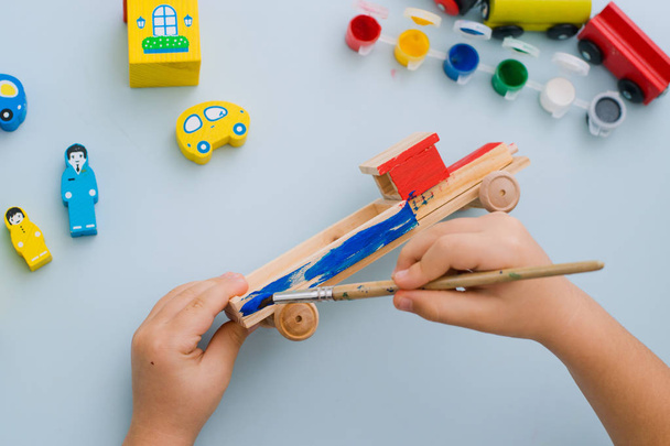 Ręce dziecka malować drewniane maszyny - Zdjęcie, obraz