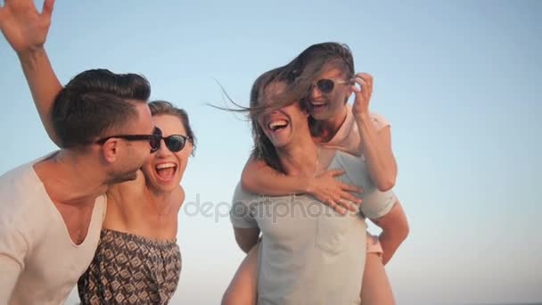 屋外のビーチでの休暇を楽しんでいる友人の幸せな若者グループの肖像画。2 つの夏の時間の間に海の近くを笑っているカップル. - 映像、動画