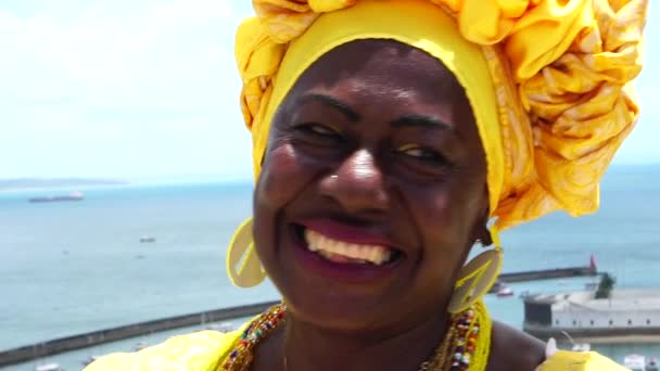 Mujer brasileña de ascendencia africana, sonriente, vestida con traje tradicional de Baiana en Ascensor Lacerda, Salvador, Bahía, Brasil
 - Imágenes, Vídeo