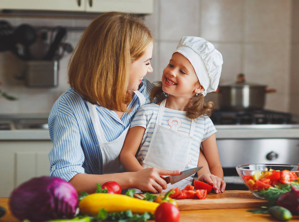 Здоровое питание. семья мать и ребенок девочка готовит вегетарианство
 - Фото, изображение
