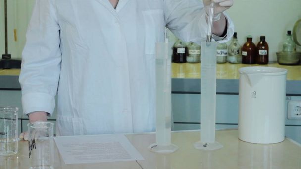 Vista parcial de cerca de científicos haciendo experimentos con reactivos y frascos. primer plano de la investigación biotecnológica en laboratorio
 - Foto, Imagen