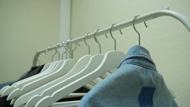 Clothes hang on a shelf in a designer clothes store. Clothes hanger - Fotó, kép