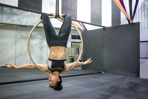 joven mujer acrobática colgando en aro aéreo
 - Foto, Imagen