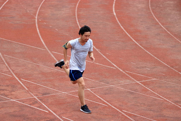 Спортсмен азіатських людині працює на іподромі в стадіон. Концепція здорового активного способу життя. - Фото, зображення