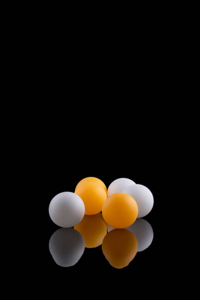 Balles blanches et orange sur fond noir
 - Photo, image