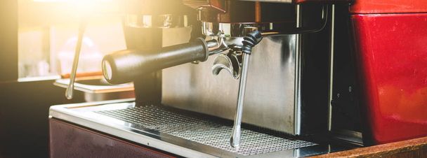Egy profi Barista Használja a kávéfőző gép főzni kávét az ügyfél megrendelésére A kávézó díszített retro stílusban, napfénnyel - Fotó, kép