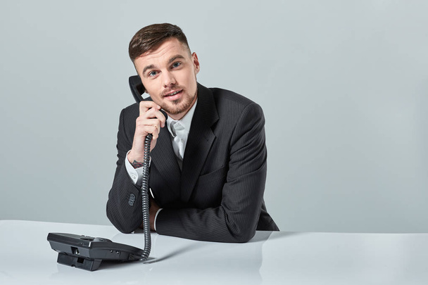 young man dials the phone number while sitting in the office - Fotó, kép