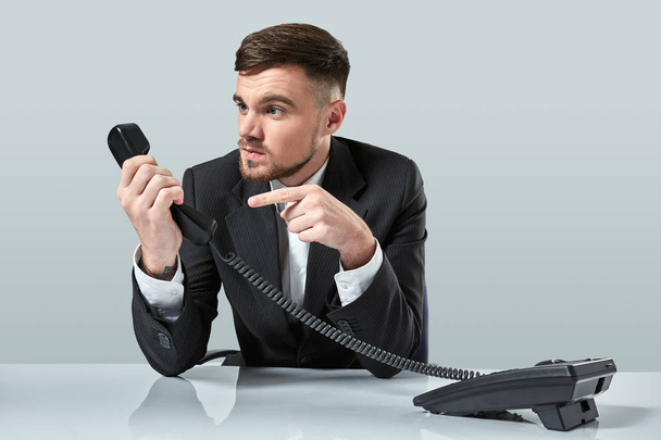 Portrait of attractive businessman holding telephone in his hand. This call is for you concept - Фото, зображення