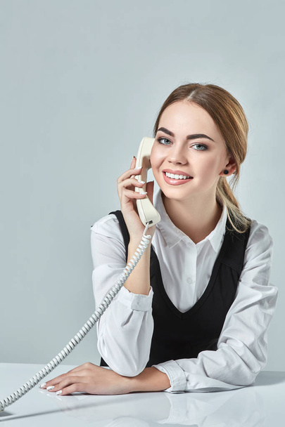 portrait of young secretary answering telephone - Photo, Image