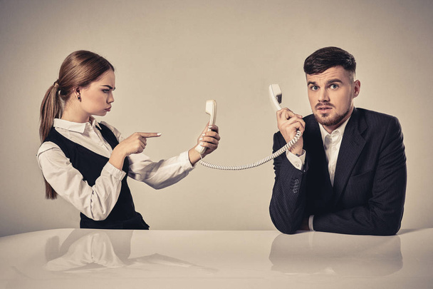 picture of man and woman with telephone at the table - Foto, Imagen