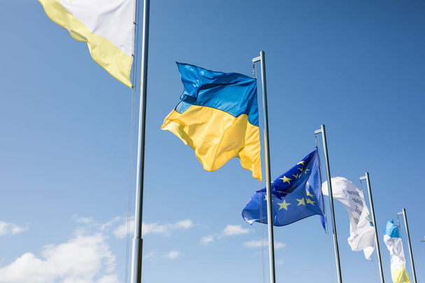 Ukrajna és az Európai Unió zászlók, zászlórudak a háttérégbolt a - Fotó, kép