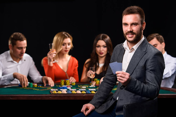 Poker gracze w kasynie z kartami i żetonami na czarnym tle - Zdjęcie, obraz