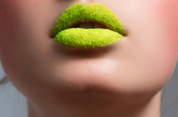 A beautiful female make-up on the lips of a green color, a close up - Photo, image