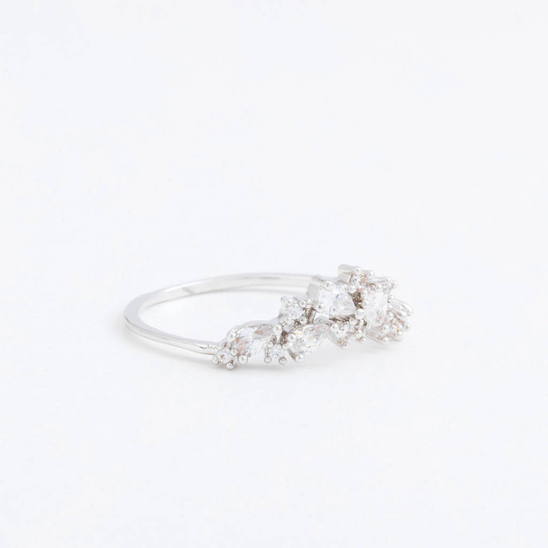 Luxurious silver jewelry ring with transparent crystals, rhinestones drops, on a grey background - Photo, Image