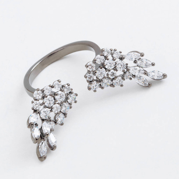 Πολυτελής ασημένια κοσμήματα δαχτυλίδι με φτερά των κρυστάλλων με γκρίζο φόντο - Φωτογραφία, εικόνα