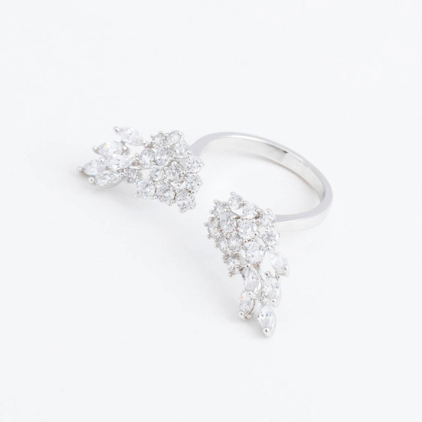Luxe zilveren sieraden ring met vleugels van kristallen met een grijze achtergrond - Foto, afbeelding