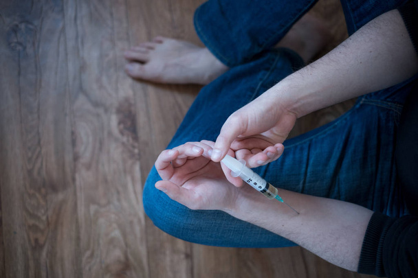 Hombre drogadicto inyectándose heroína en su brazo
 - Foto, imagen